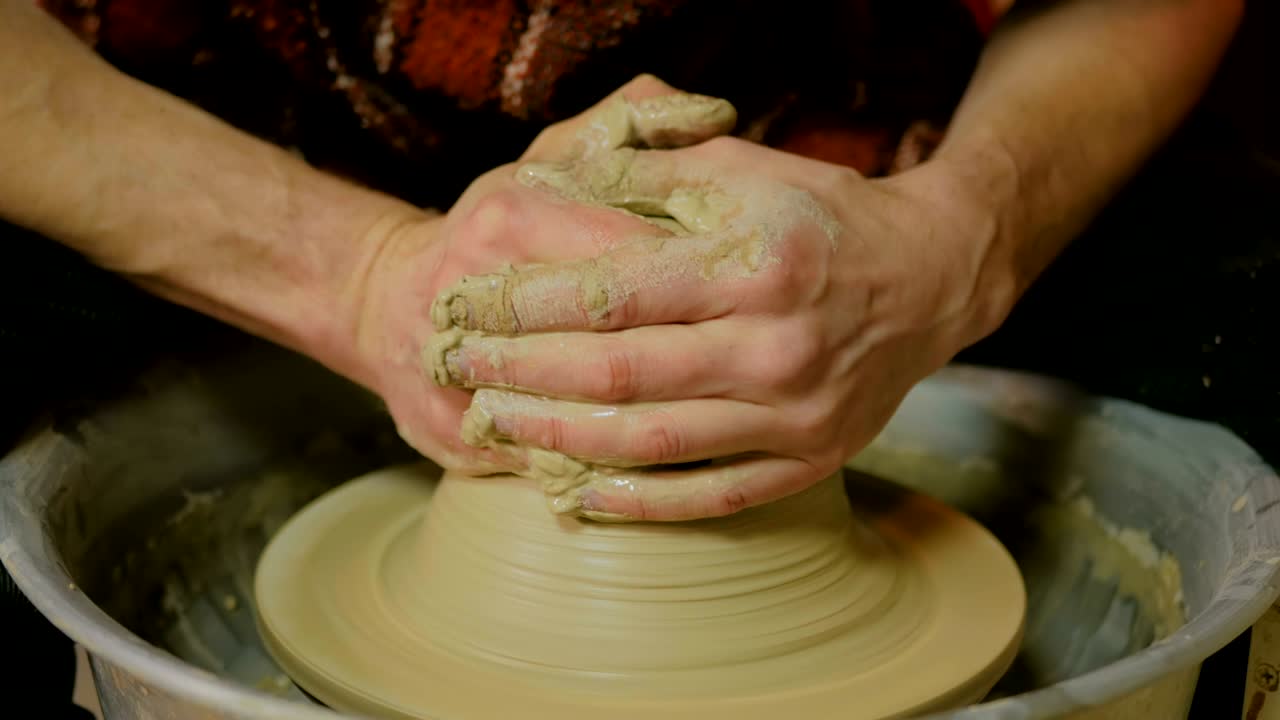 un alfarero profesional que trabaja con arcilla en la rueda del alfarero