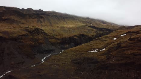 aerial landscape view of water flowing in a valley from sólheimajökull glacier, iceland, in summer