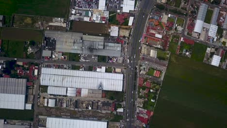 Top-view-of-warehouses-in-the-industrial-park-of-the-town-of-chalco,-Mexico-with-a-view-of-the-roads-and-traffic