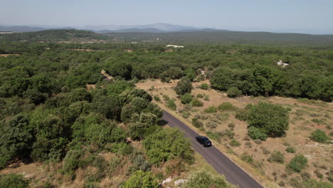 coche eléctrico negro conduciendo campo al sur de francia día soleado