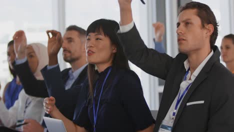 Audience-at-a-seminar-raising-hands-to-ask-questions