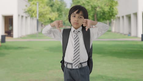 disappointed indian school  boy showing thumbs down