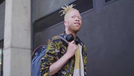 happy albino african american man with dreadlocks walking