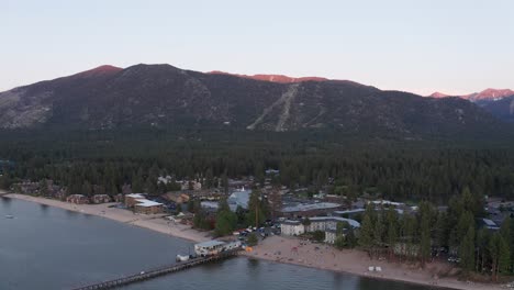 reverse pullback and panning aerial shot of south lake tahoe at low light in the summer