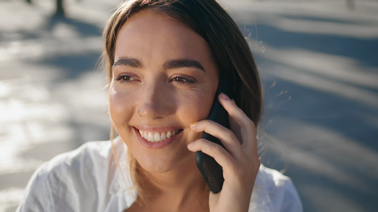 adolescente alegre hablando por teléfono móvil en la calle soleada de primer plano. chica feliz hablando