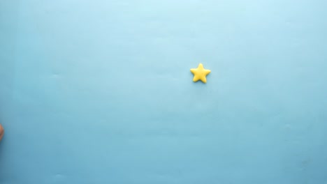 hand touching yellow stars on light blue background