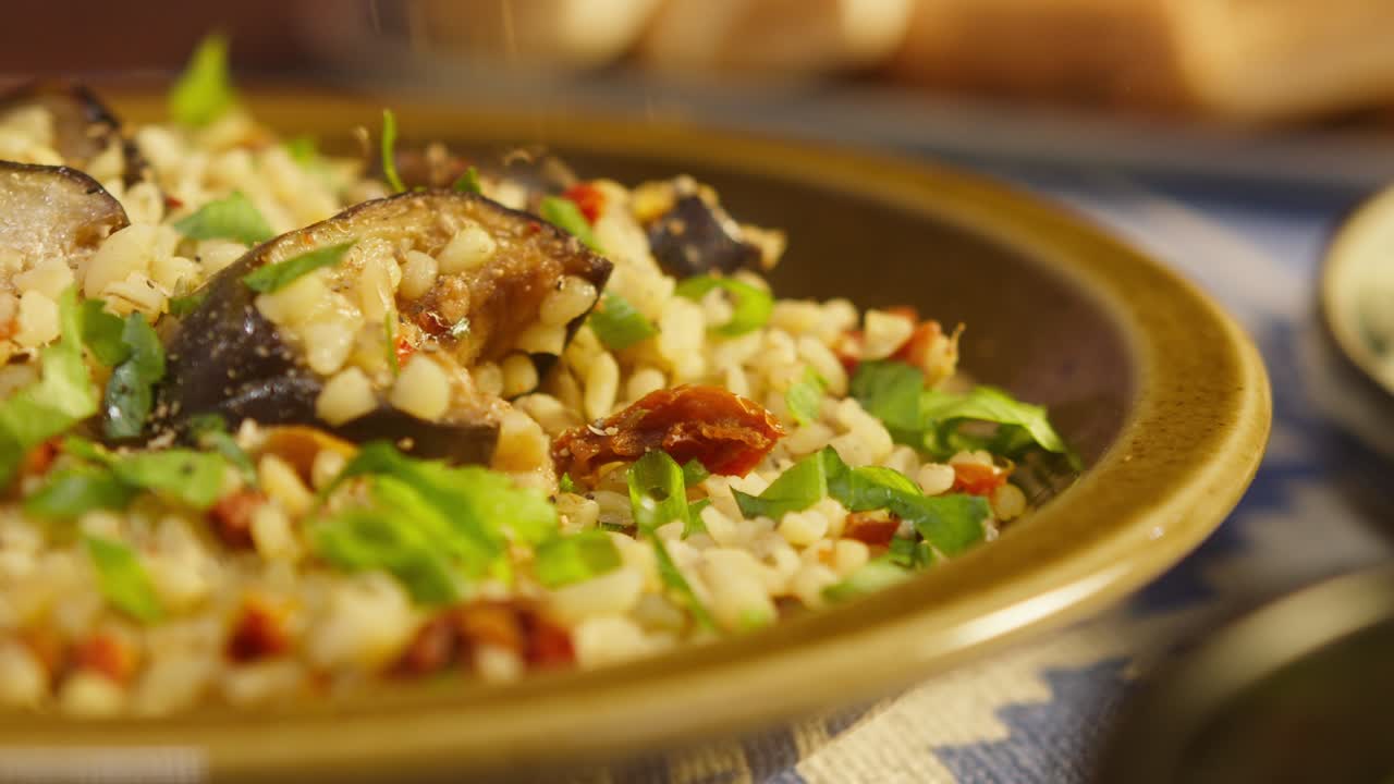 rociar especias en bulgur con berenjena de primer plano, añadiendo pimienta. cultura tradicional de oriente medio. delicioso arroz con carne. cocina árabe. concepto de comida casera