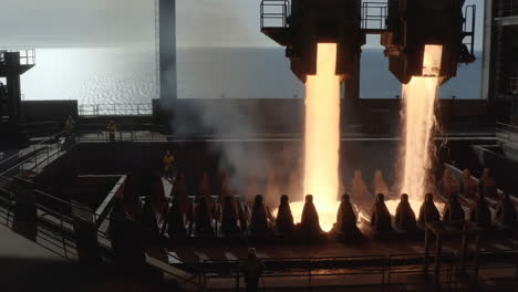 Molten metal pouring in an industrial facility by the sea