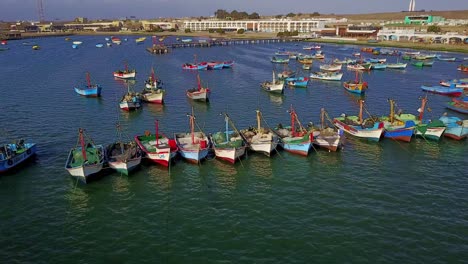 Luftaufnahme-Einer-Drohne-Von-Fischerbooten-In-Der-Bucht-Von-Paracas-In-Peru-Entlang-Des-Strandes-El-Chaco