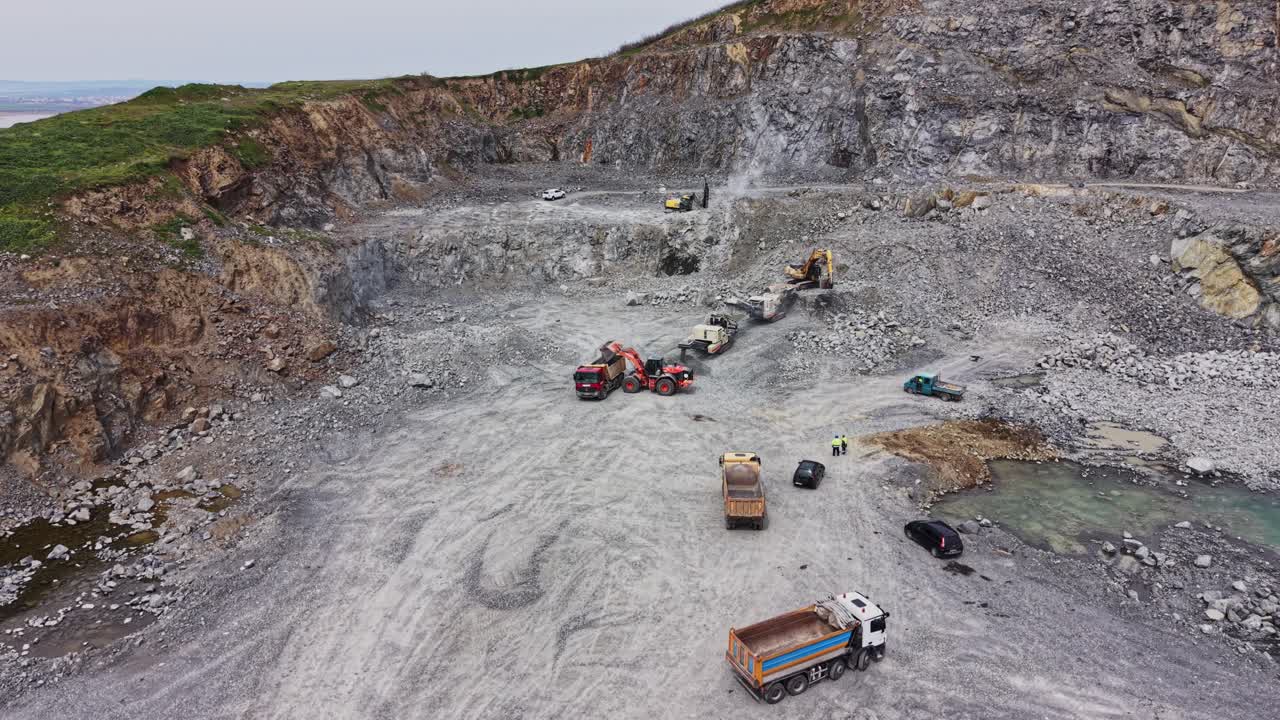 Aerial View of Heavy Machinery Working in a Large Open-Pit Quarry