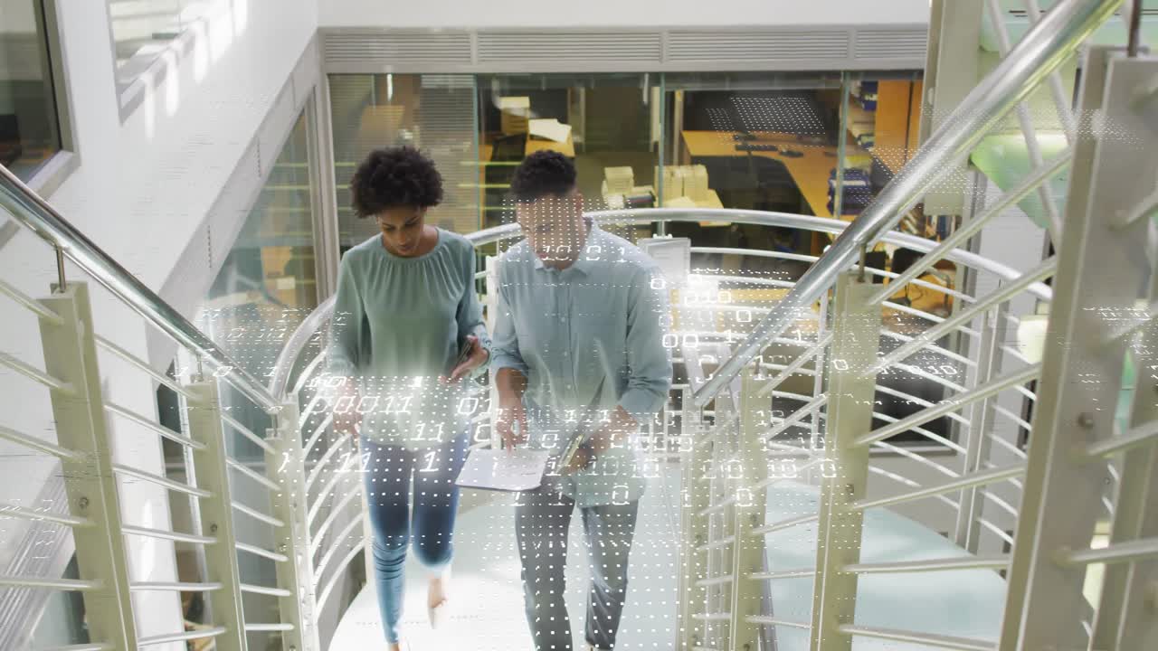 Hombre entrando al atrio de la oficina y mujer colaborando revisando gráficos con superposición de datos empresariales.