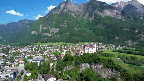 luftaufnahme der europäischen burg liechtenstein mit der stadt balzers unten und den bergen