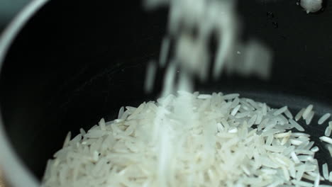 extreme close up of rice pouring into saucepan