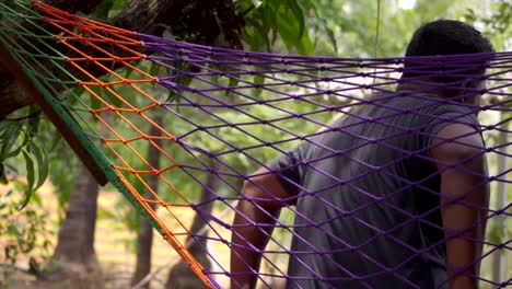 un hombre sentado en un árbol zula para relajarse