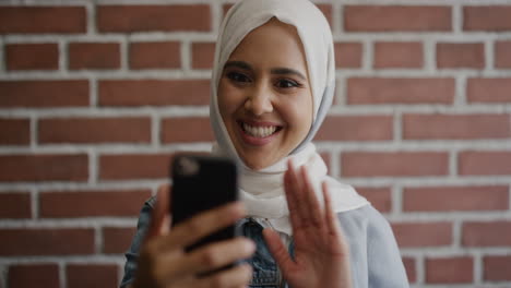 portrait-young-happy-muslim-woman-using-smartphone-video-chat-waving-hand-enjoying-mobile-communication-beautiful-female-student-wearing-hijab-headscarf