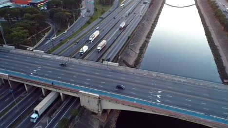 aerial view of cars, bus and trucks on highway in sao paulo city, brazil. tiete's river scenery. great traffic scene. fantastic landscape. freeway, traffic, speed.
