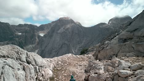 Persona-Caminando-Mientras-El-Dron-Pasa-Cerca,-Permitiéndole-Ver-Un-Gran-Valle-Remoto