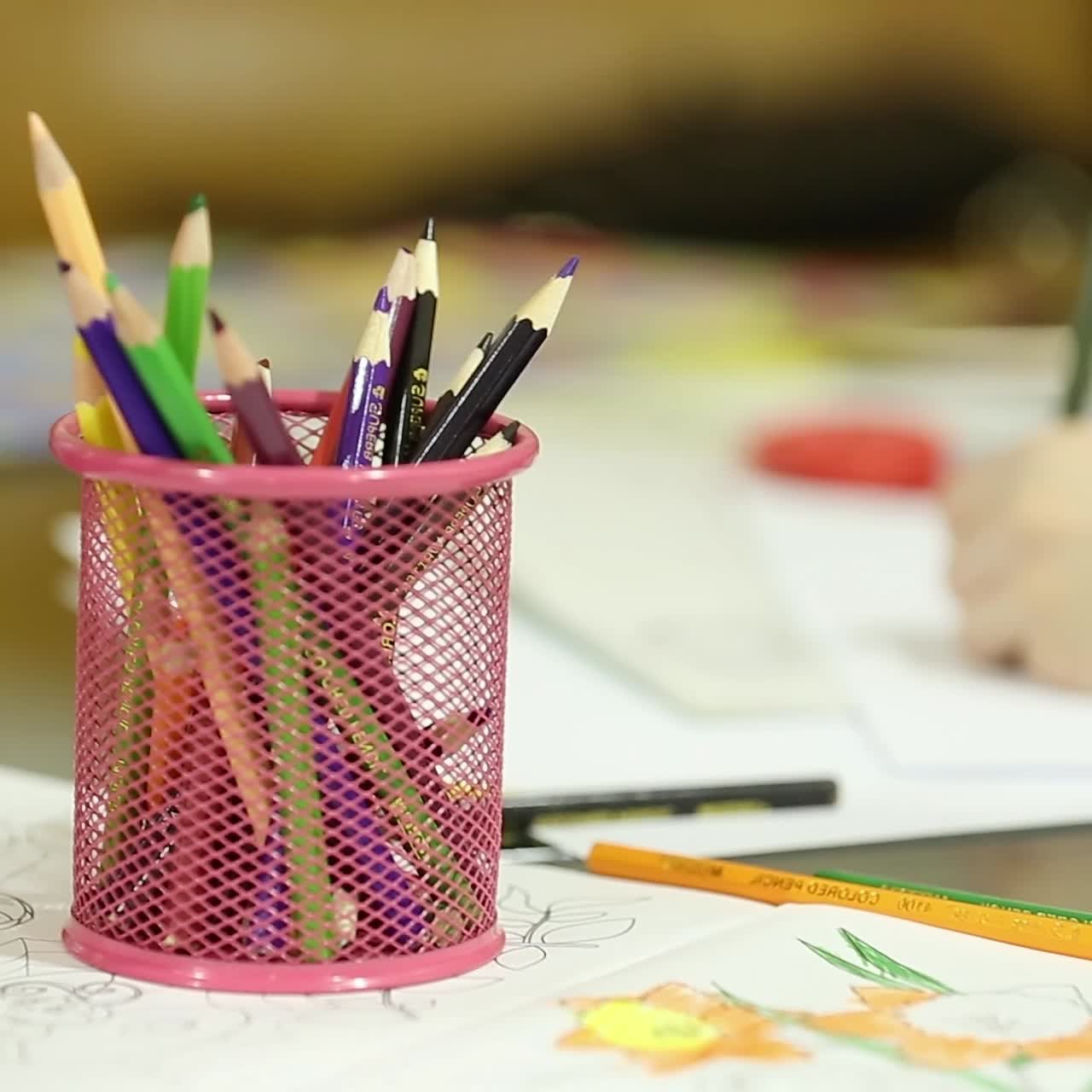 niños pequeños sentados en la mesa dibujando con lápices