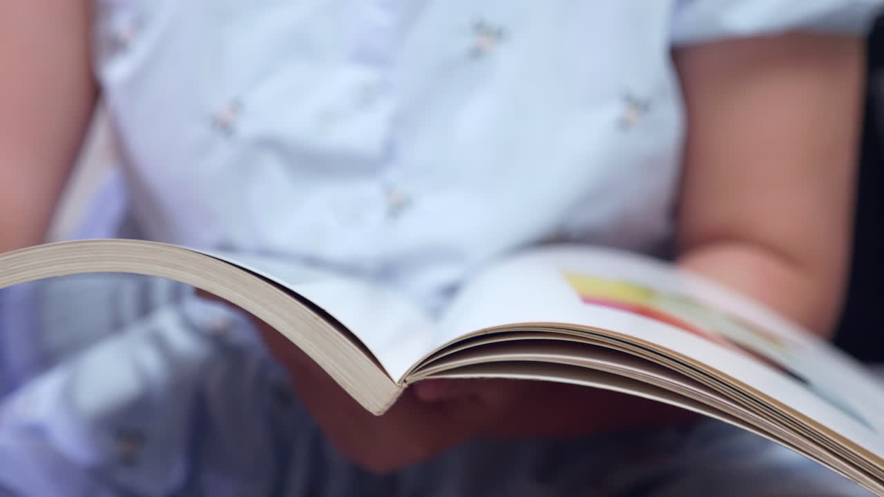 revisando las páginas mientras lee un libro ilustrado de colores