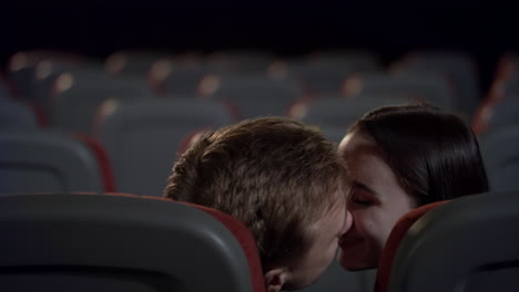 loving couple kissing in back seats in cinema in slow motion.