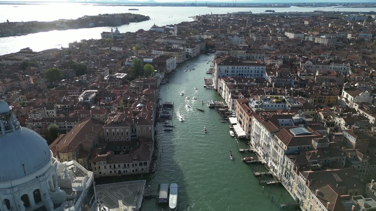 Aerial perspective of Venice's Grand Canal filled with boats amidst historic buildings.