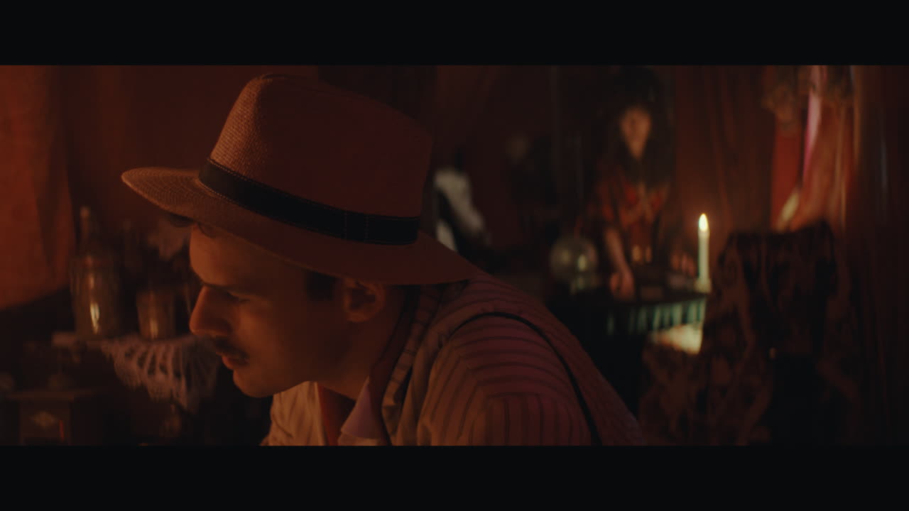 A man in hat checks the inside of the gypsy circus cart
