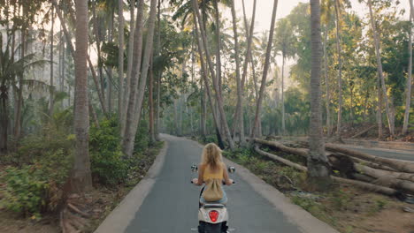 Mujer-Viajera-Montando-Motocicleta-En-Una-Isla-Tropical-Disfrutando-De-Una-Aventura-De-Viaje-Por-Carretera-En-Moto-Vista-Trasera-De-Scooter