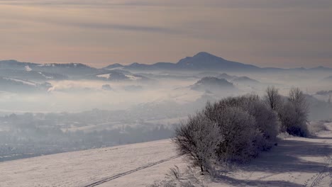 stunning panoramic view of winter landscape with mountains and village in distance