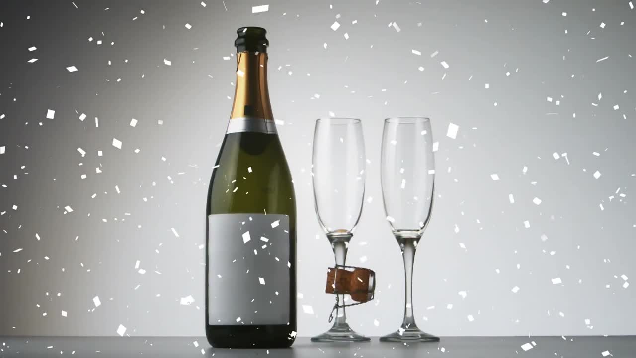 Animazione di coriandoli che cadono sopra una bottiglia e bicchieri di champagne.