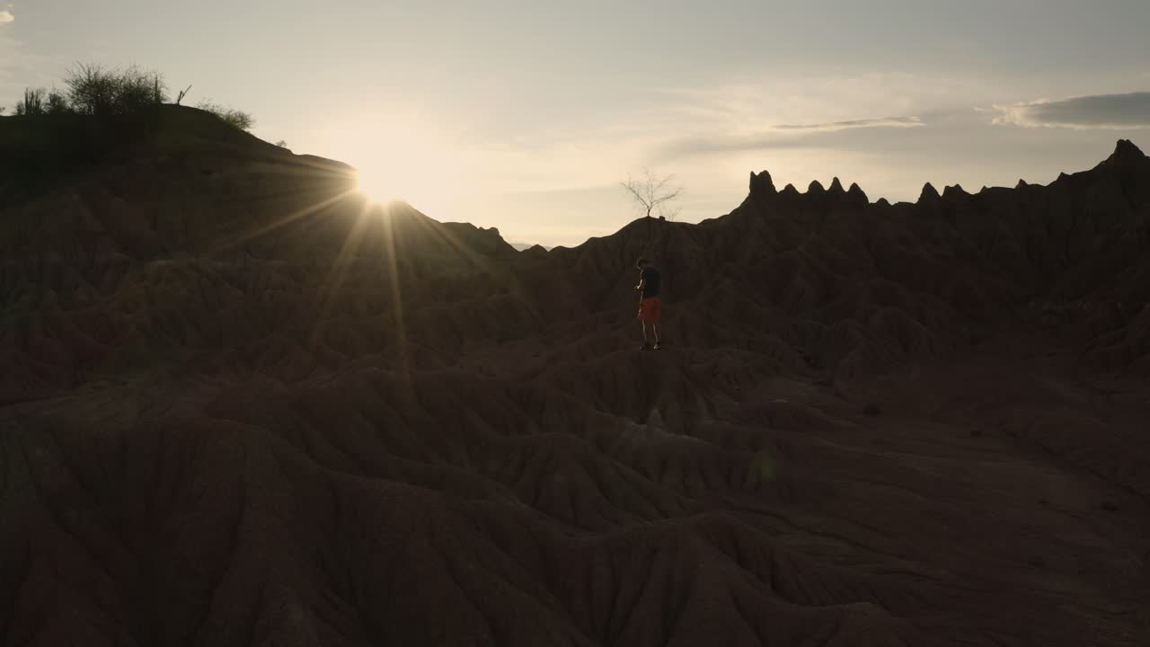 en flyvemaskine flyver rundt om en person i den gyldne time i tatacoa-ørkenen i colombia
