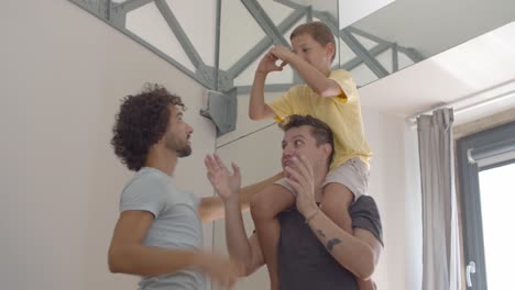 joyful excited child riding on dads necks