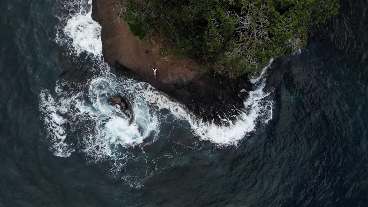 Strong sea waves splashing and crashing on the rocky, green shoreline of Costa Rica - top view