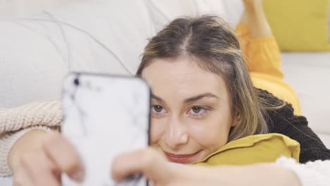 happy teenage girl holding mobile phone using smartphone device at home.