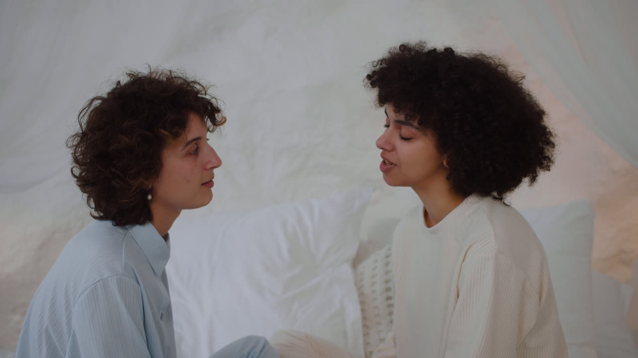 una pareja lgbt hablando en la cama.