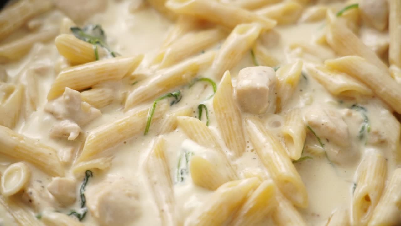 человек, готовящий макароны в сковороде