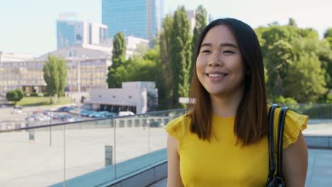 una chica de negocios asiática feliz sonriendo mientras camina