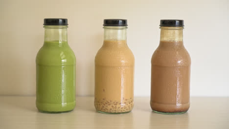 matcha green tea latte, chocolate and milk tea with pudding jelly in glass bottle on the table