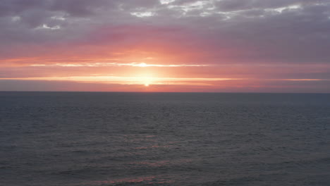 the lighthouse of westkapelle during a bright orange sunset, with a lot of wind