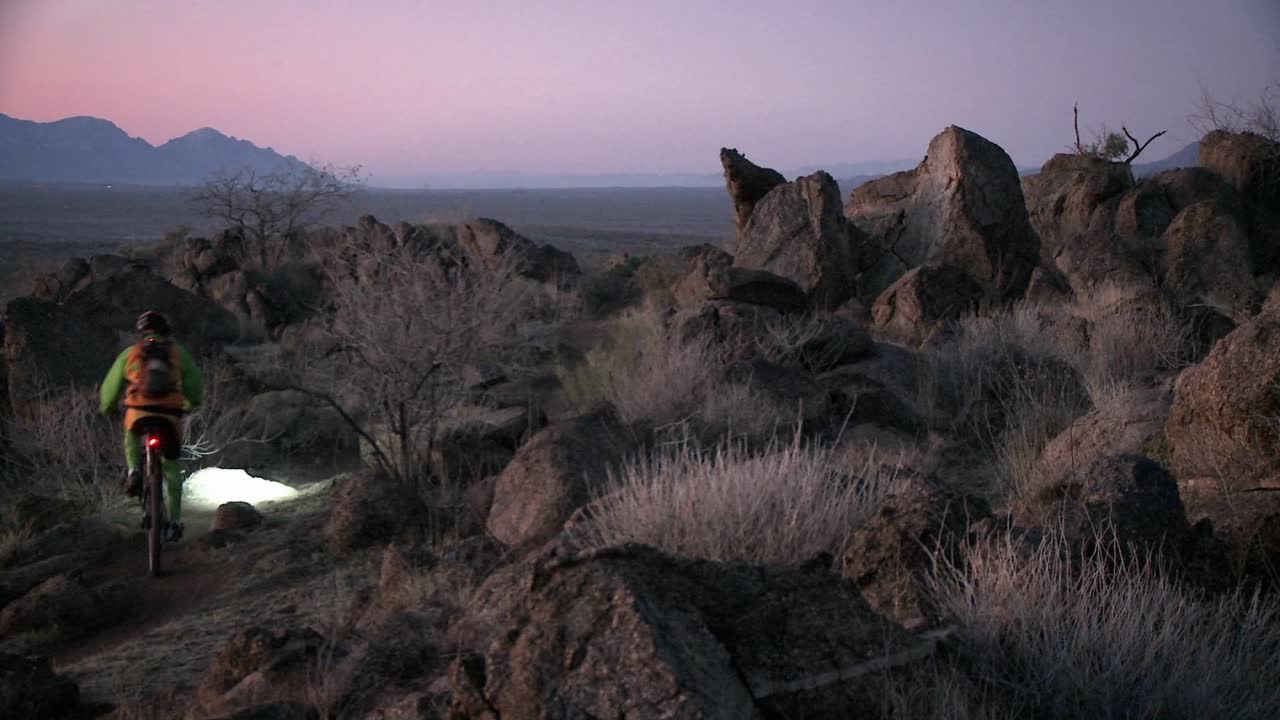 一名骑自行车的人在晚上穿过山区