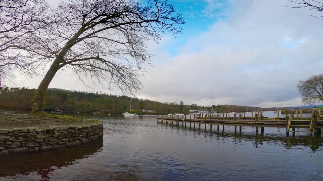 Lago Windermere nel Distretto dei Laghi inglese, con il suo iconico molo in legno, storici edifici in pietra e cieli grigi e cupi