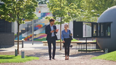 colleagues strolling street together on lunch break. smiling couple talking