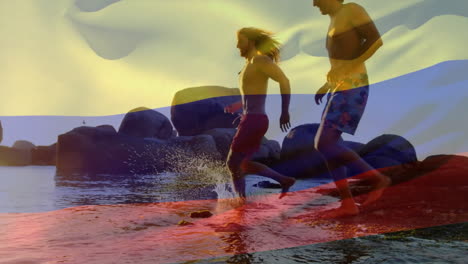 animation of colombian flag over diverse friends running on sunny beach