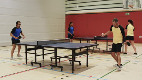 playing table tennis, group of people enjoying game in indoor sports hall