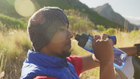 Sporty-mixed-race-man-with-prosthetic-leg-drinking-water