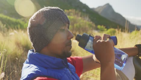 sporty mixed race man with prosthetic leg drinking water