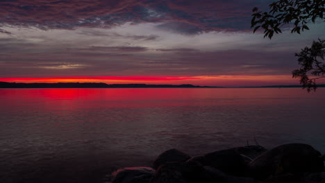 time-laspe of a blazing red sunset over a lake