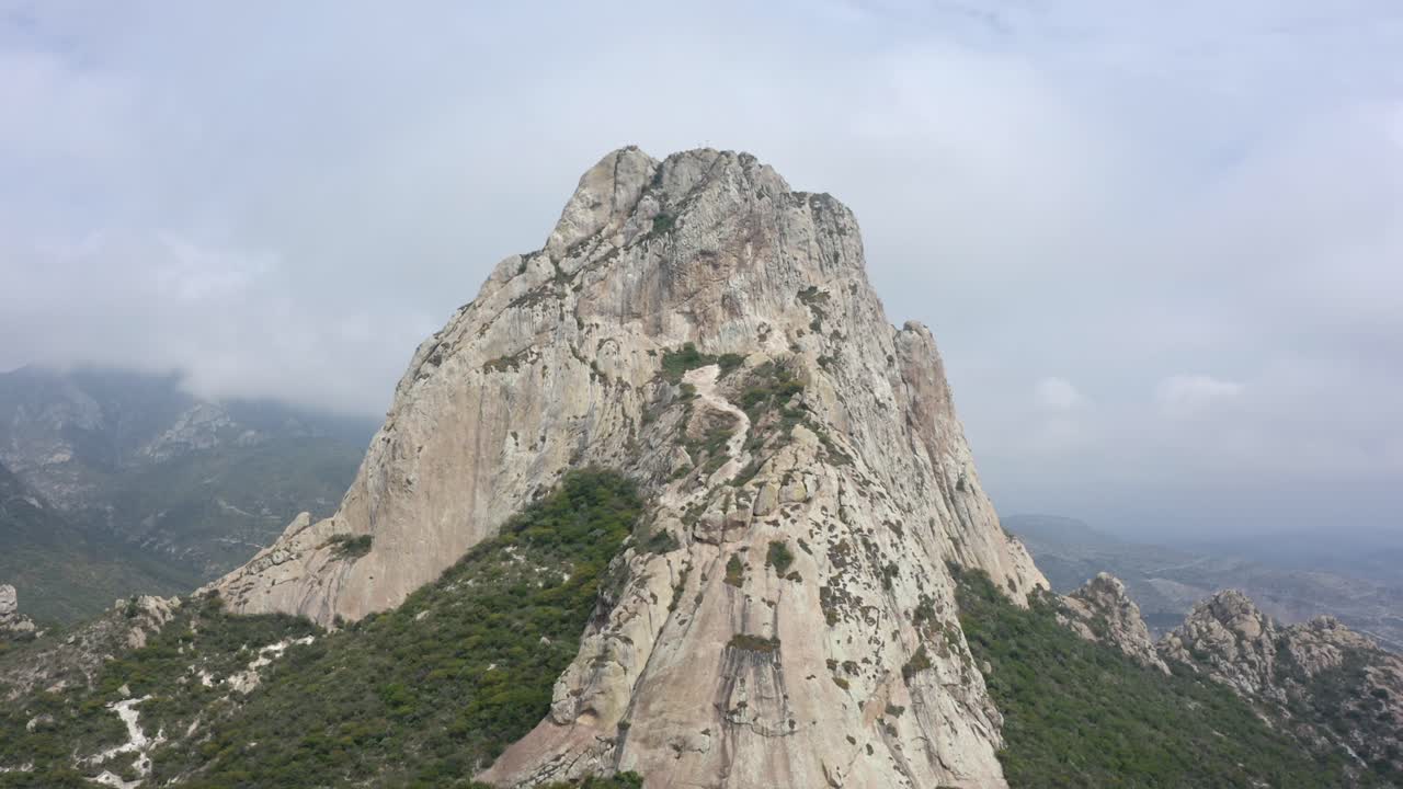 DRONE: CRANE SHOT OF PEÑA DE BERNAL IN QUERÉTARO, MEXICO ON A CLOUDY DAY