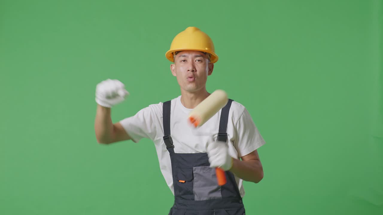 Asian Man Painter Wearing Safety Helmet Dancing While Standing In The Green Screen Background Studio