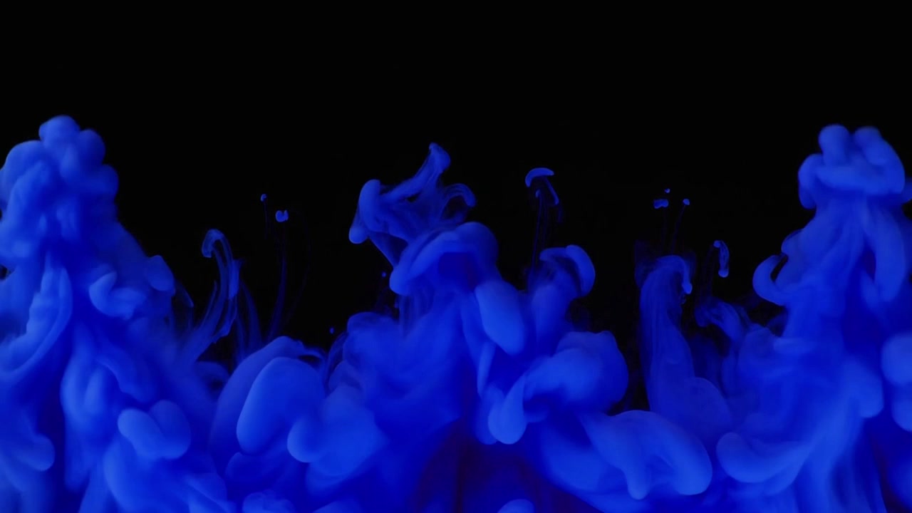 Inchiostro blu che si diffonde nell'acqua su sfondo nero