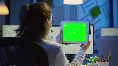 mujer de negocios sosteniendo una tableta con un monitor de pantalla verde